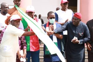 Delta State Governor, Senator Dr. Ifeanyi Okowa (2nd right) looks on as the PDP Chairman, Anambra state, Hon. Ndubuisi Nwobu (right) hands over PDP flag to Mr. Magnus Eziokwu who led APGA decampees to PDP when the Party's (PDP) Governorship candidate, Valentine Ozigbo (2nd left), led them and his other supporters on a visit to the Governor in Government House, Asaba.